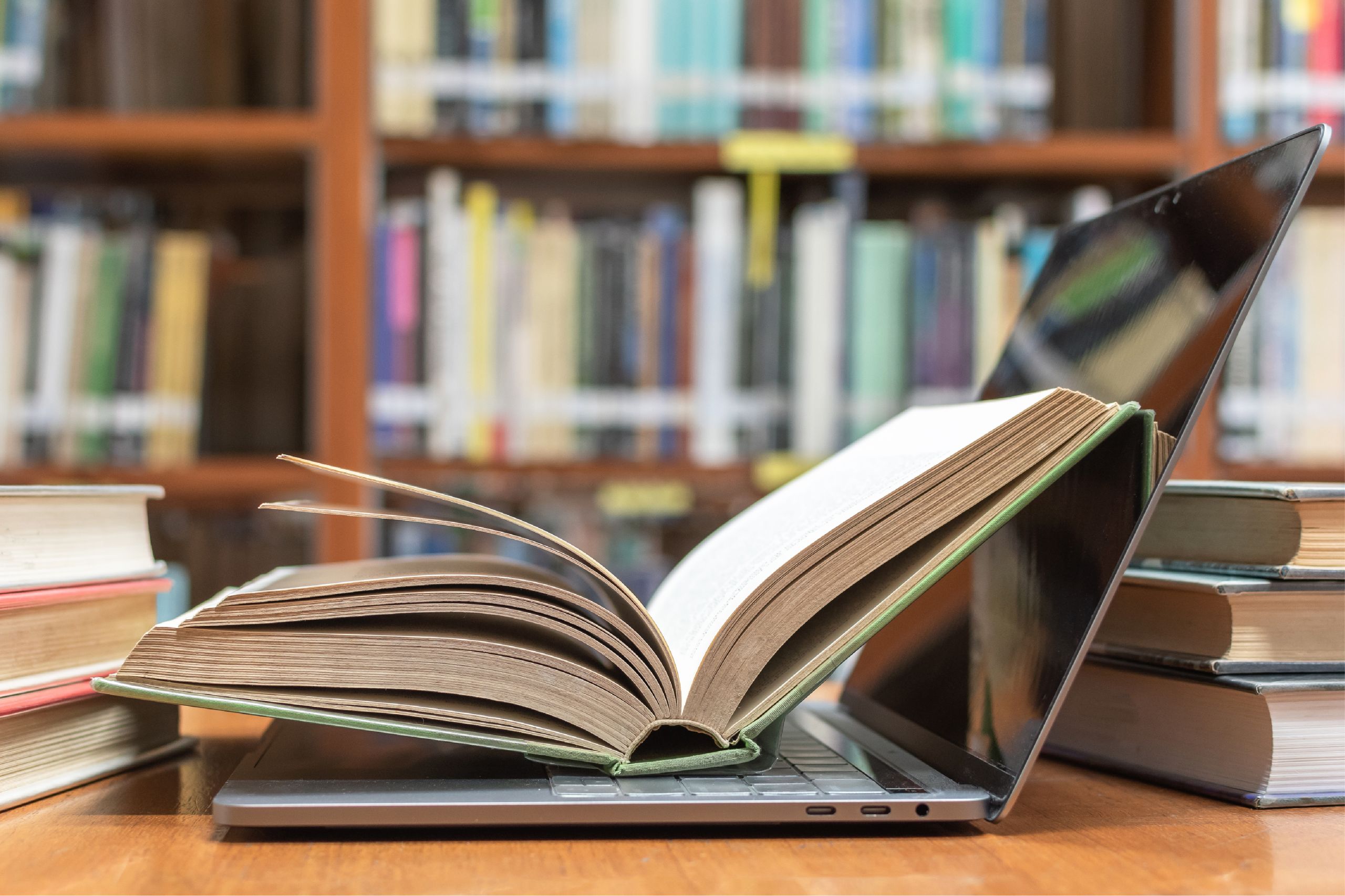 book resting on laptop in library