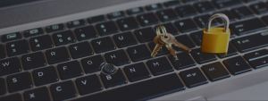 Golden locked padlock and keys on laptop keyboard.